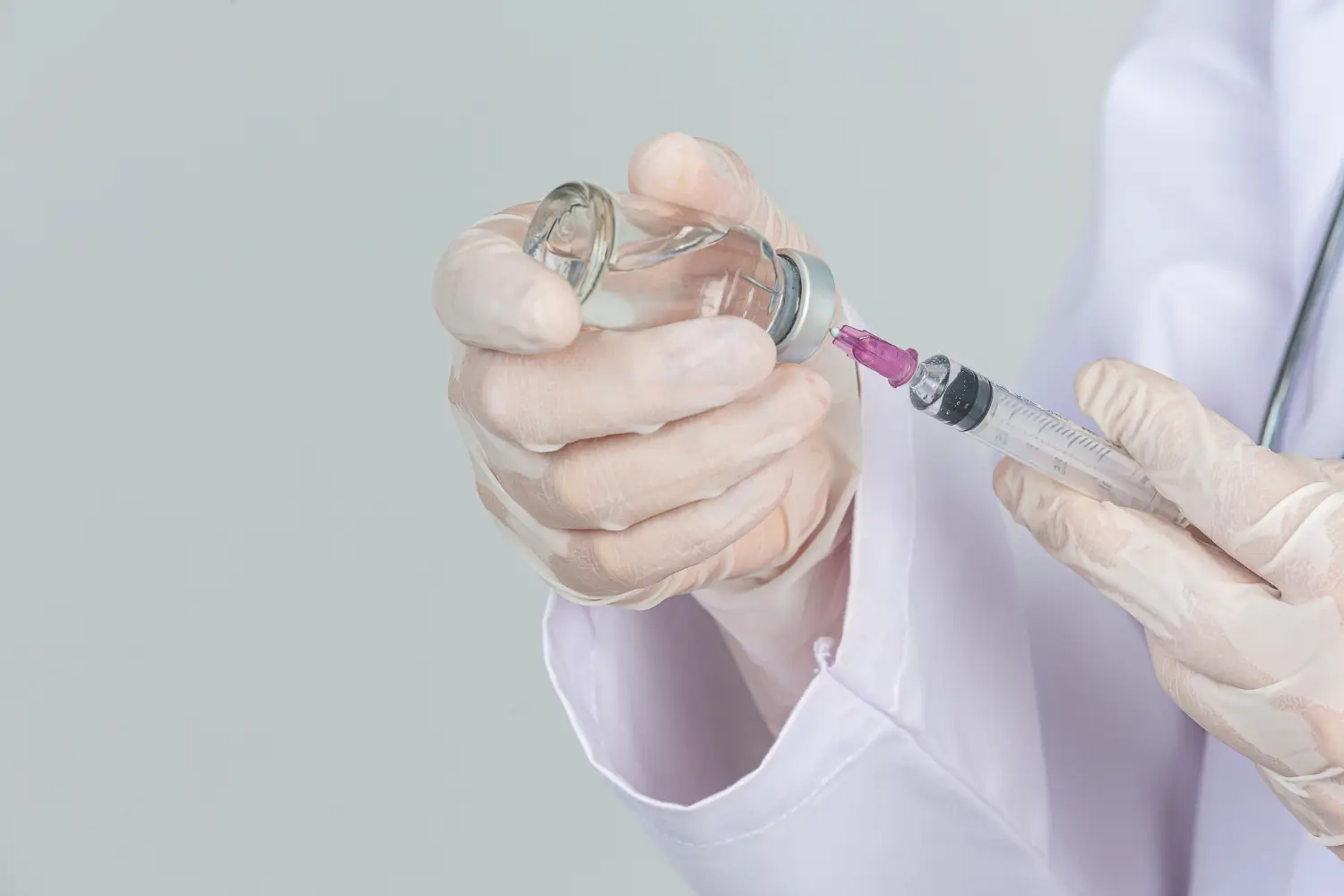 A medical professional preparing an injection.