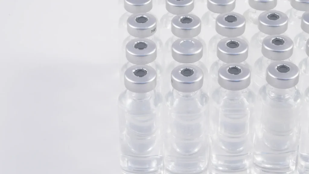 Multiple medicine vials lined up on a surface.