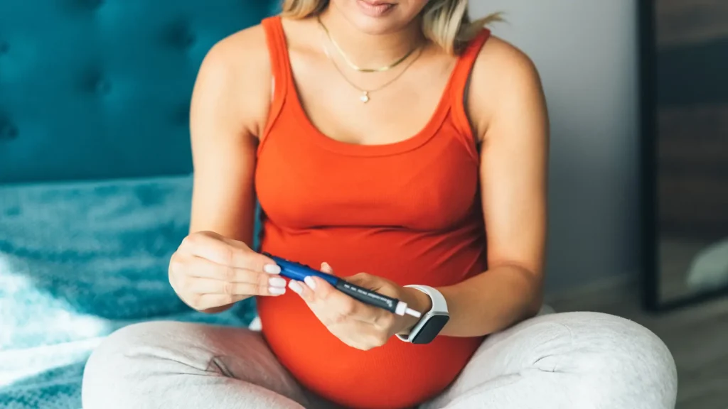 A pregnant woman preparing her injection pen for administration.
