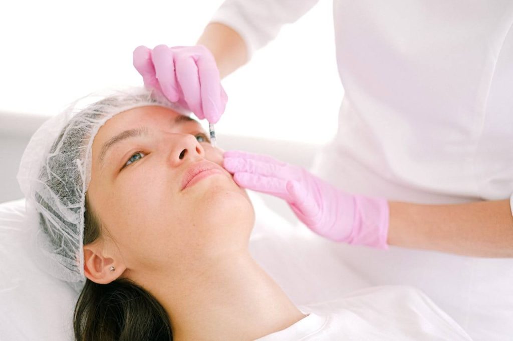 cosmetologist injecting a woman face botox