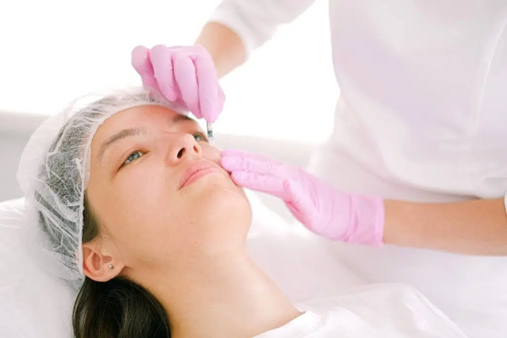 cosmetologist injecting a woman face botox
