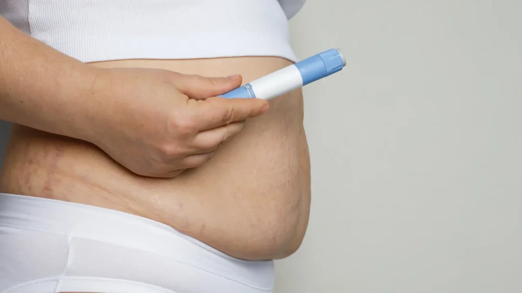 An individual holding a self-injection pen.