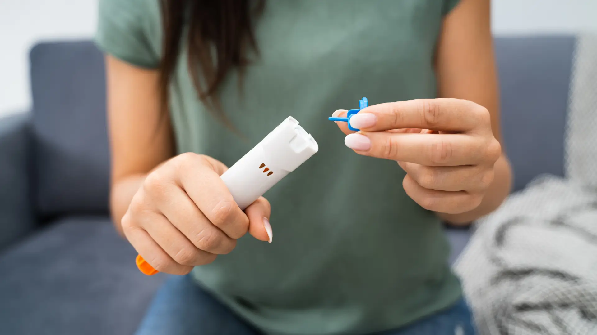 An individual preparing an autoinjector syringe.