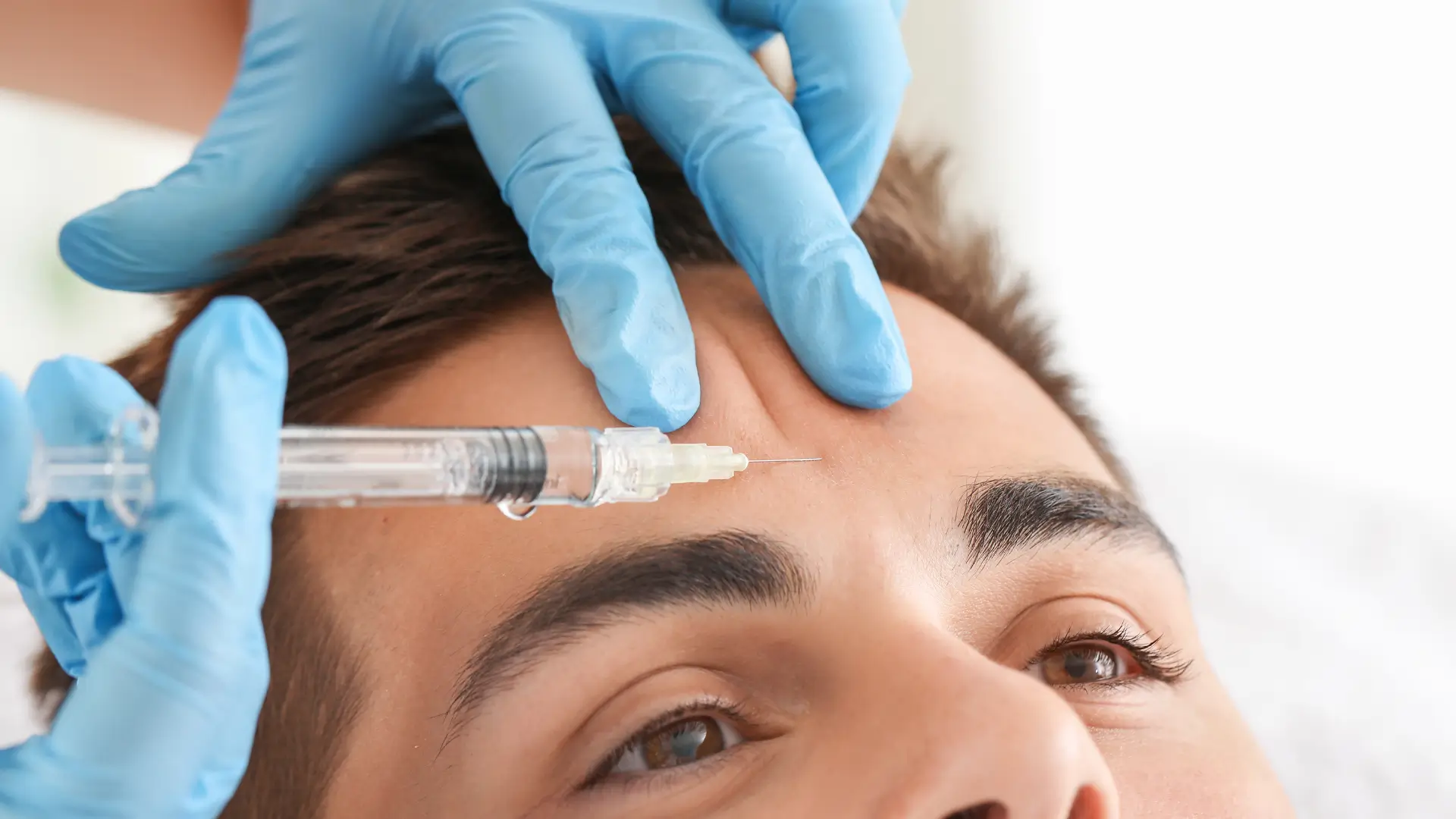 A male individual undergoing an aesthetic facial inejction treatment.