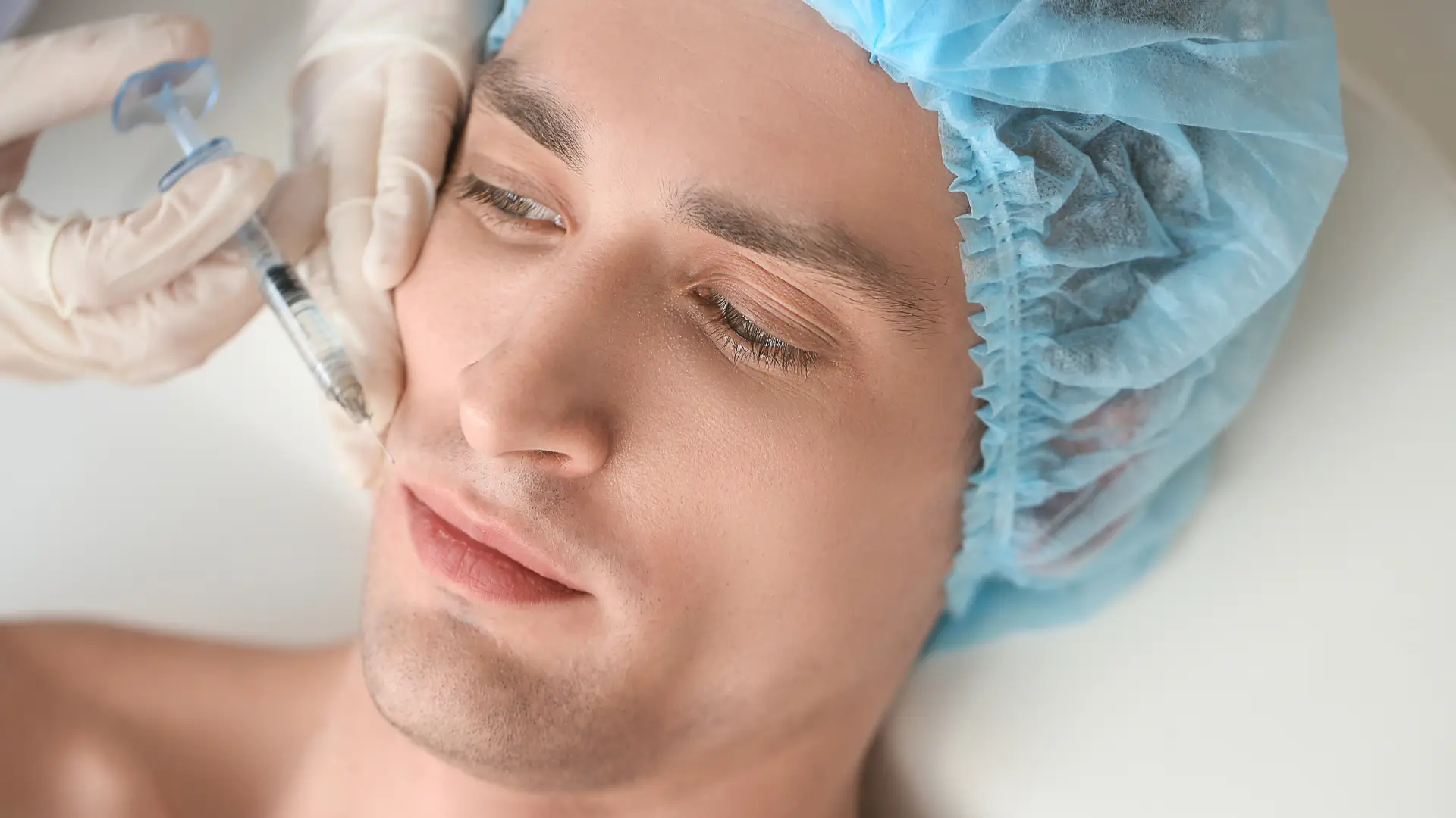 A male individual receiving a facial injection treatment.