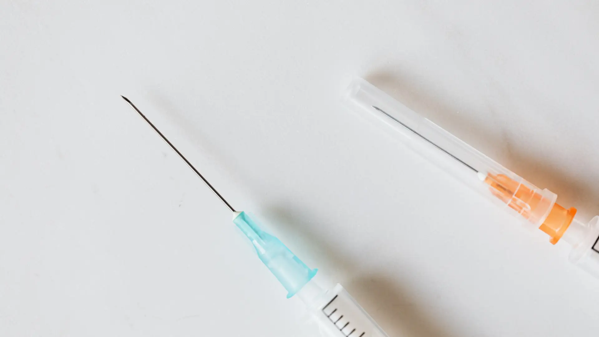 Two medical syringes on a table.