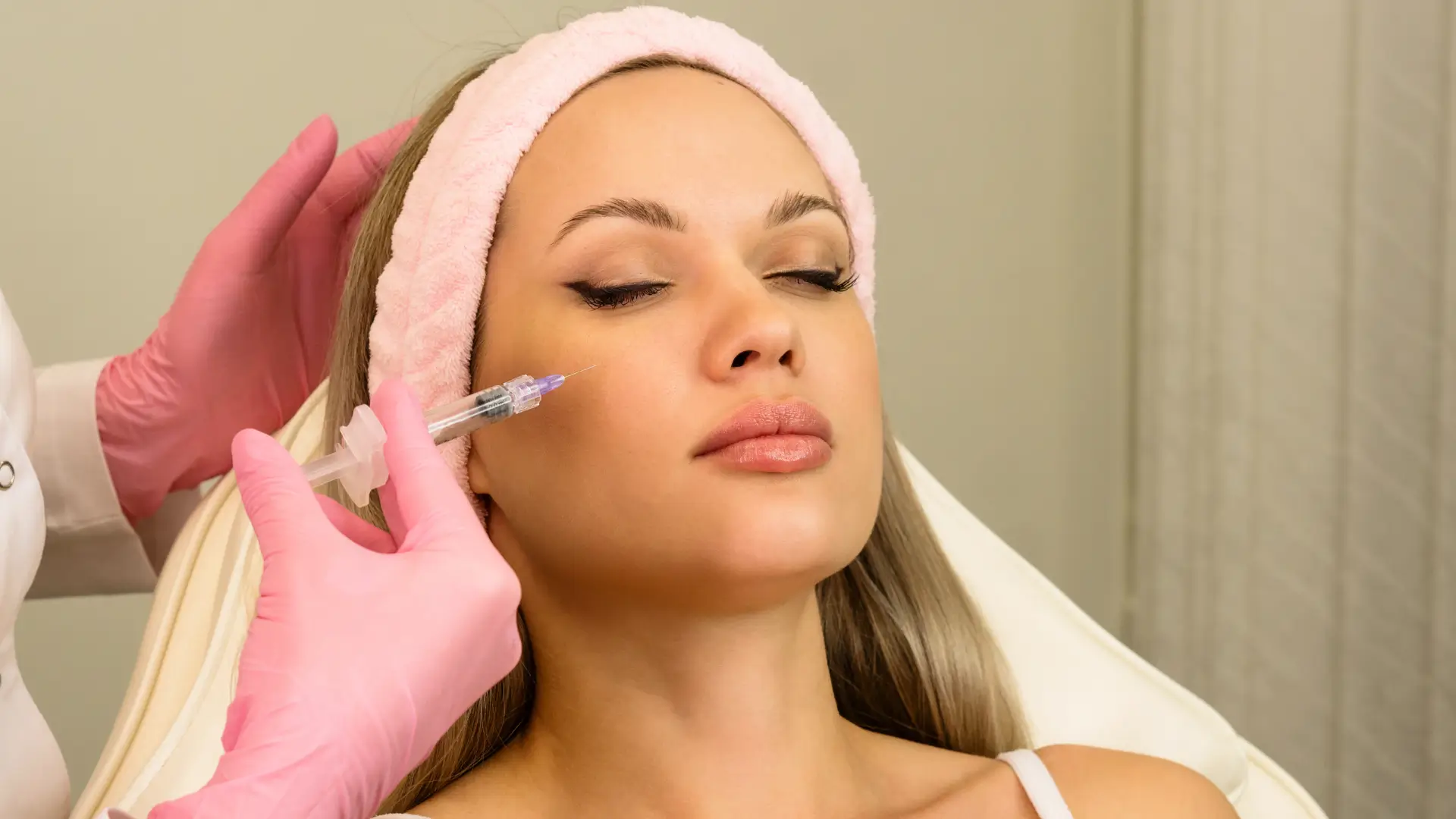 An individual undergoing a skin injection treatment for their face.