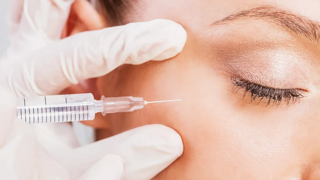 An individual undergoing an aesthetic injection for their eye region.