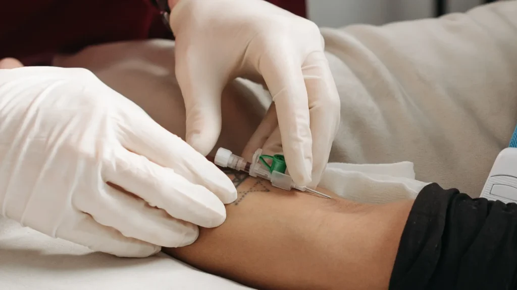A medical professional inserting a needle on a patient.