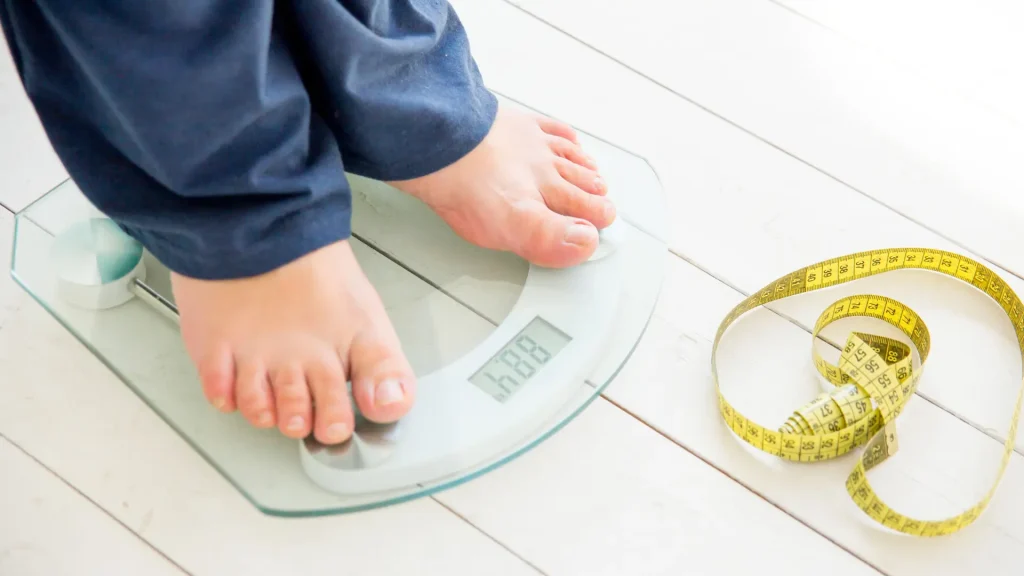 An individual checking their weight through a weighing scale.