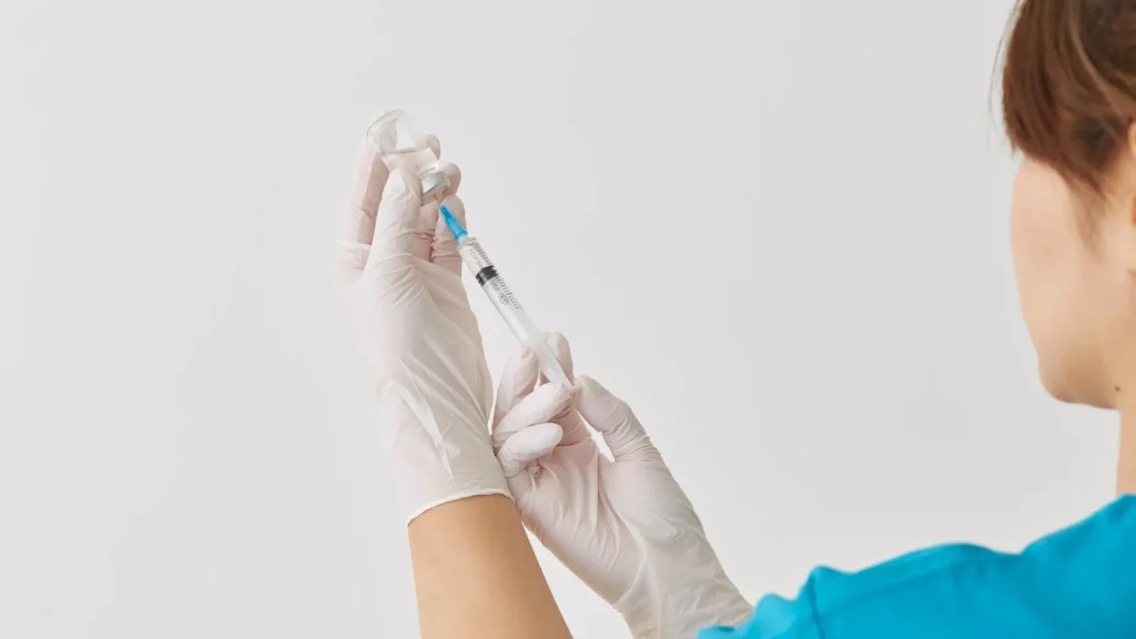 A medical professional preparing an injectin syringe.