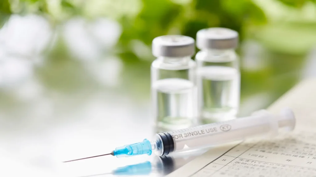 A close-up shot of two medicine vials and a syringe.