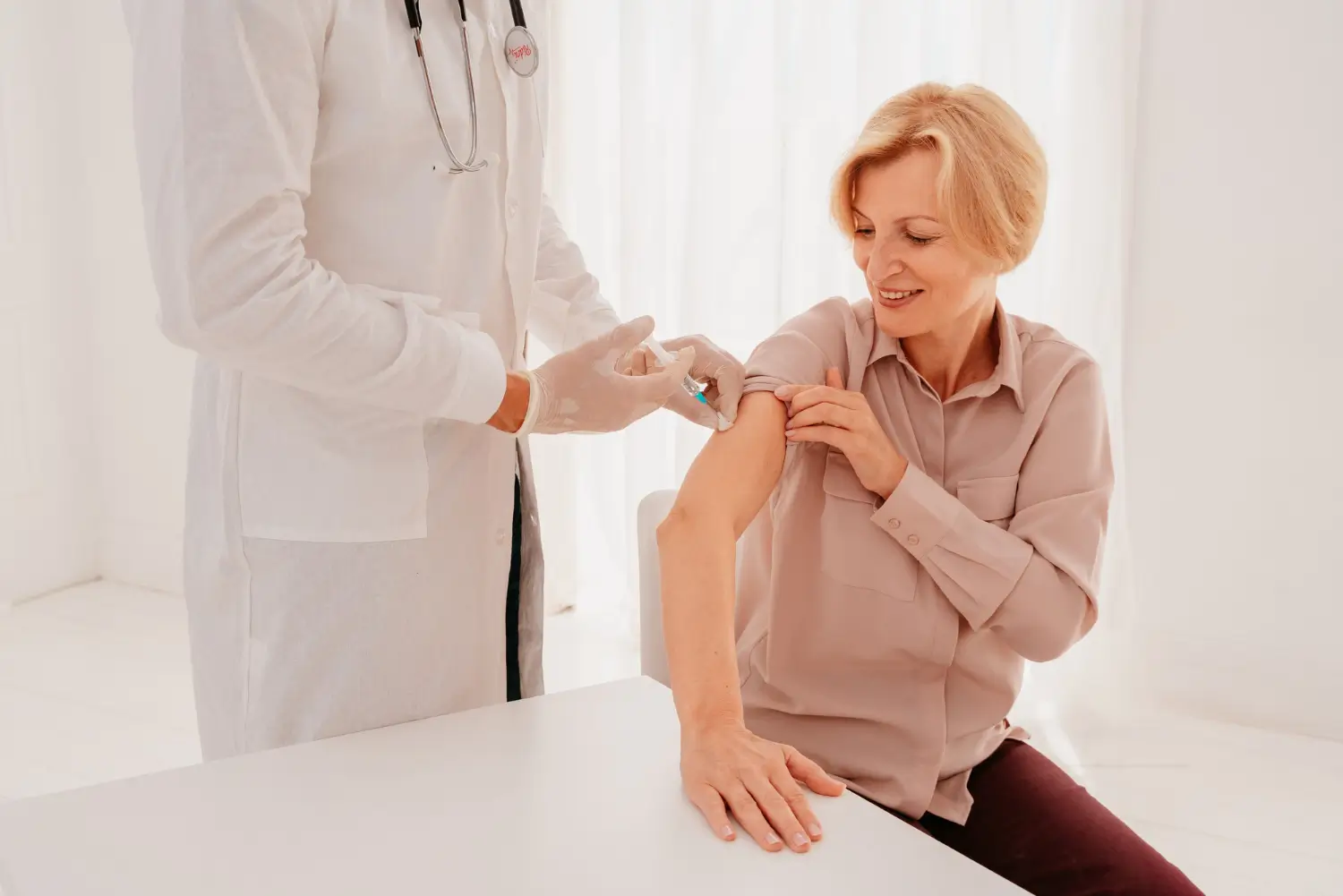 An older individual receiving an injection from a medical professional.