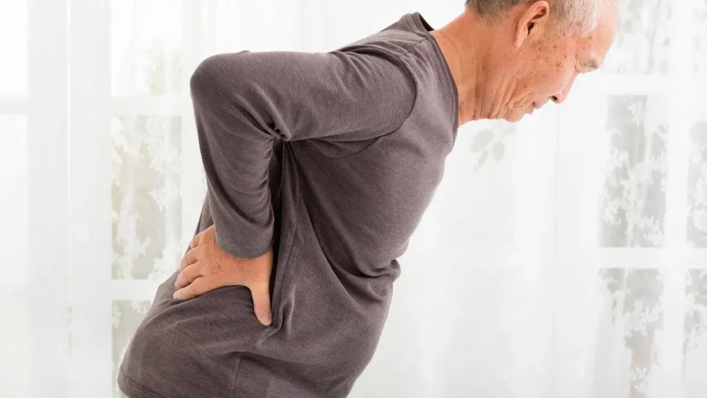 An older individual dealing with back pain.