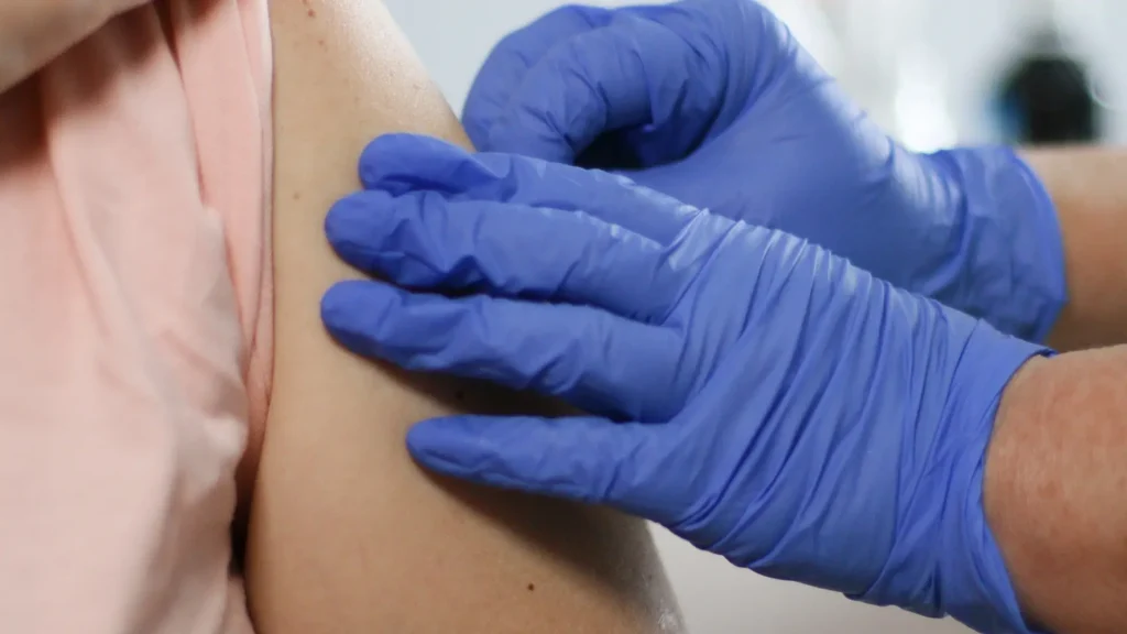 A medical professional preparing the patient's injection site.