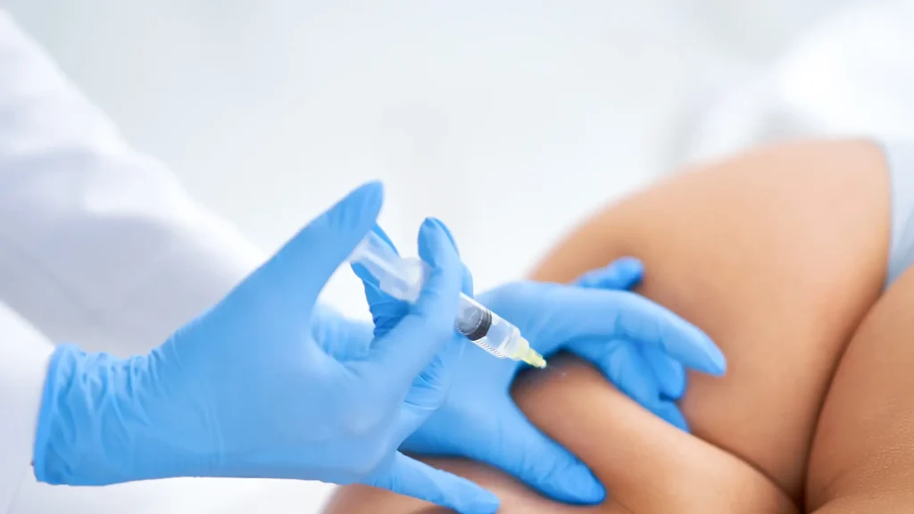 A medical practitioner administering a buttock injection.