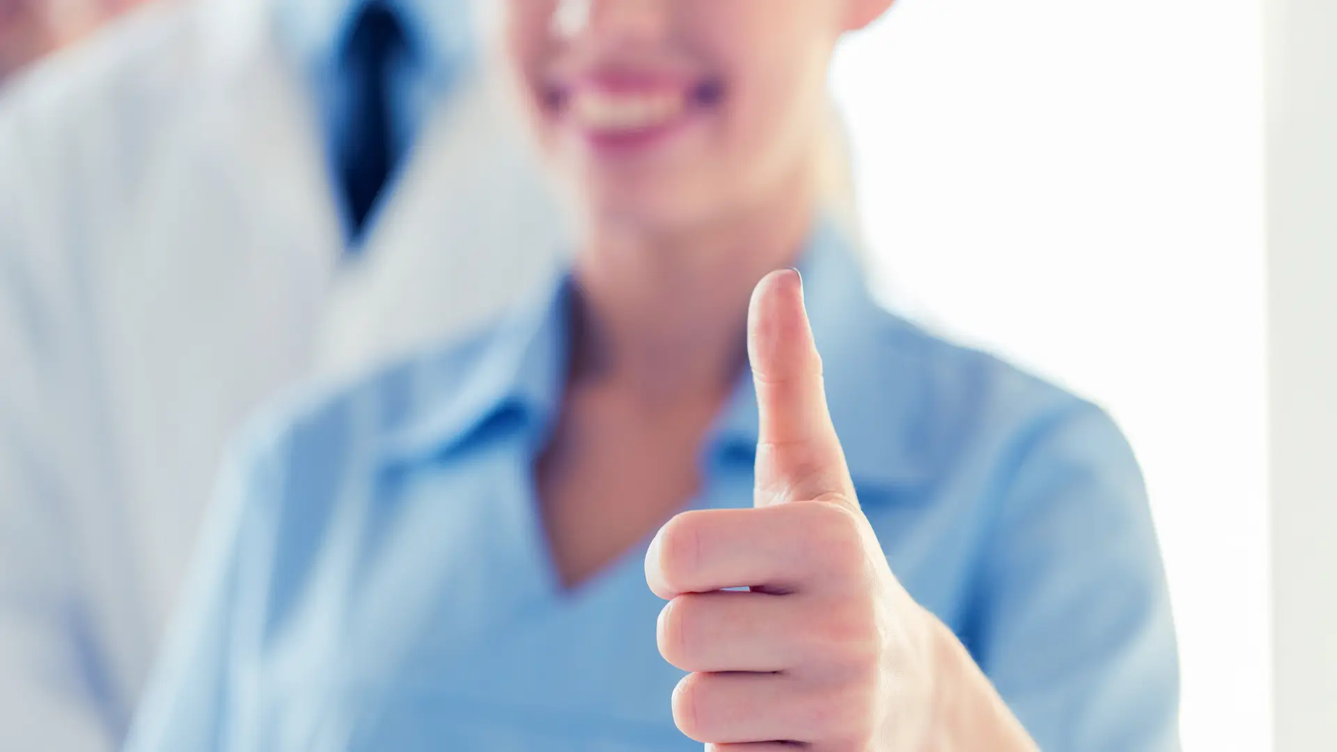 A medical professional showing a thumbs up.