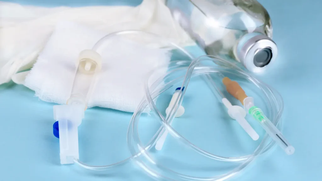 Disposable IV infusion set on a blue surface.