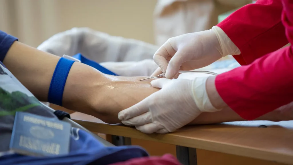 A medical professional preparing a patient for an infusion treatment.
