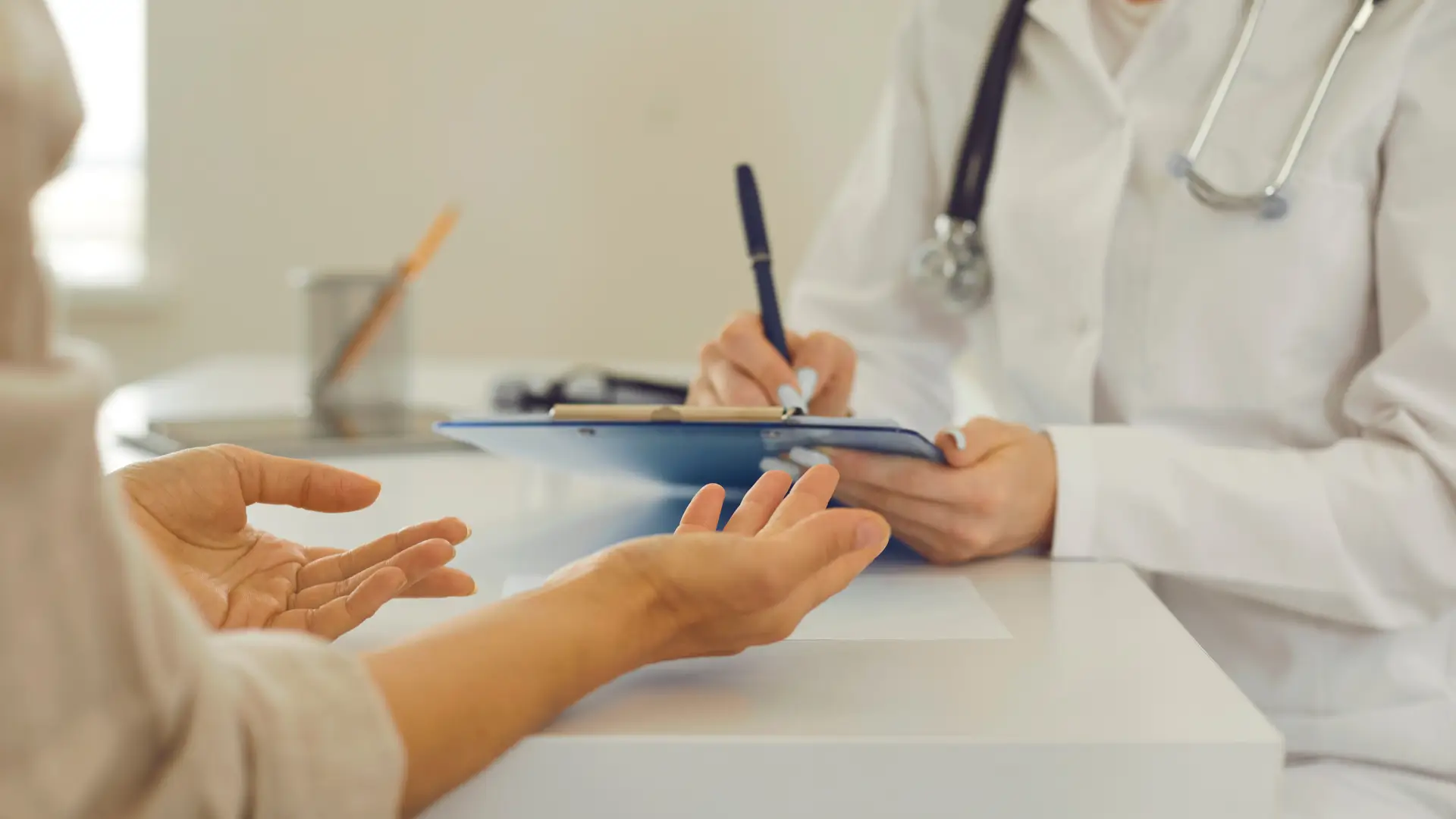 A medical professional writing the patient's health complaints before giving them a prescription.
