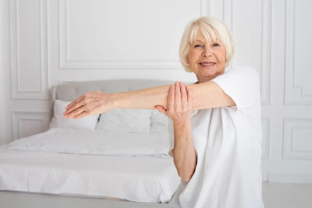 An older woman happily and confidently stretching her arm.