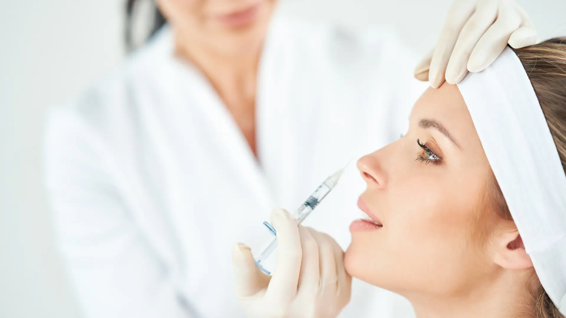 A medical professionals administering a botox injection for their facial region.