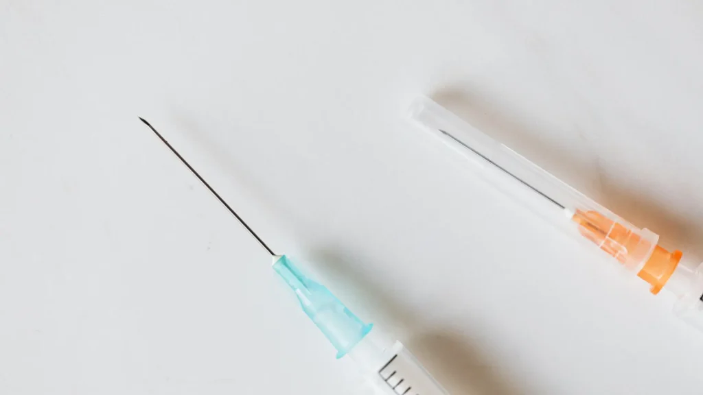 Two injection syringes on a surface.