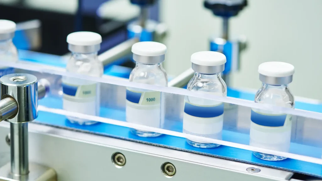 Pharmaceutical glass bottles on a conveyor belt.