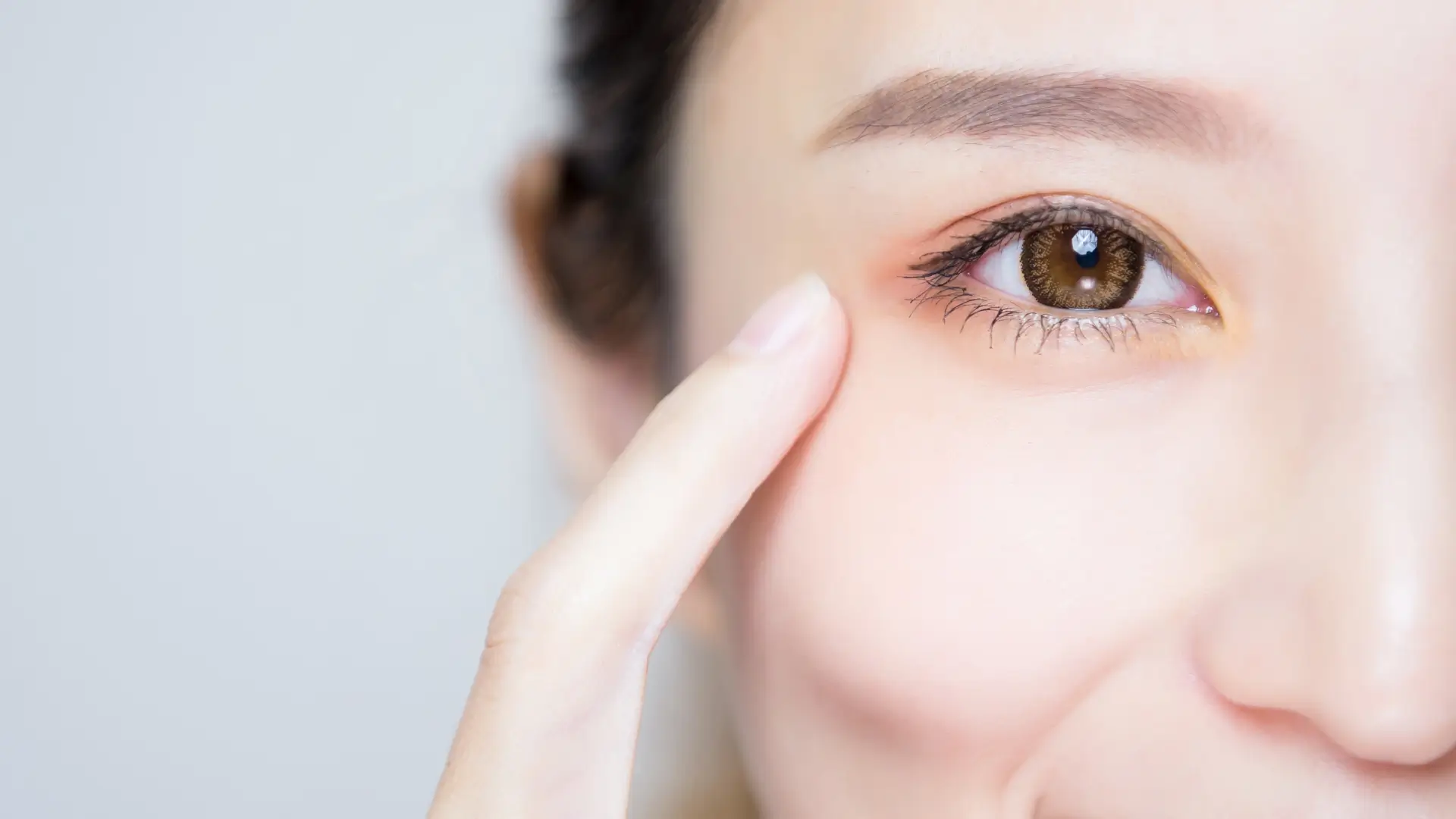 A close-up shot of an individual pointing to their eye.