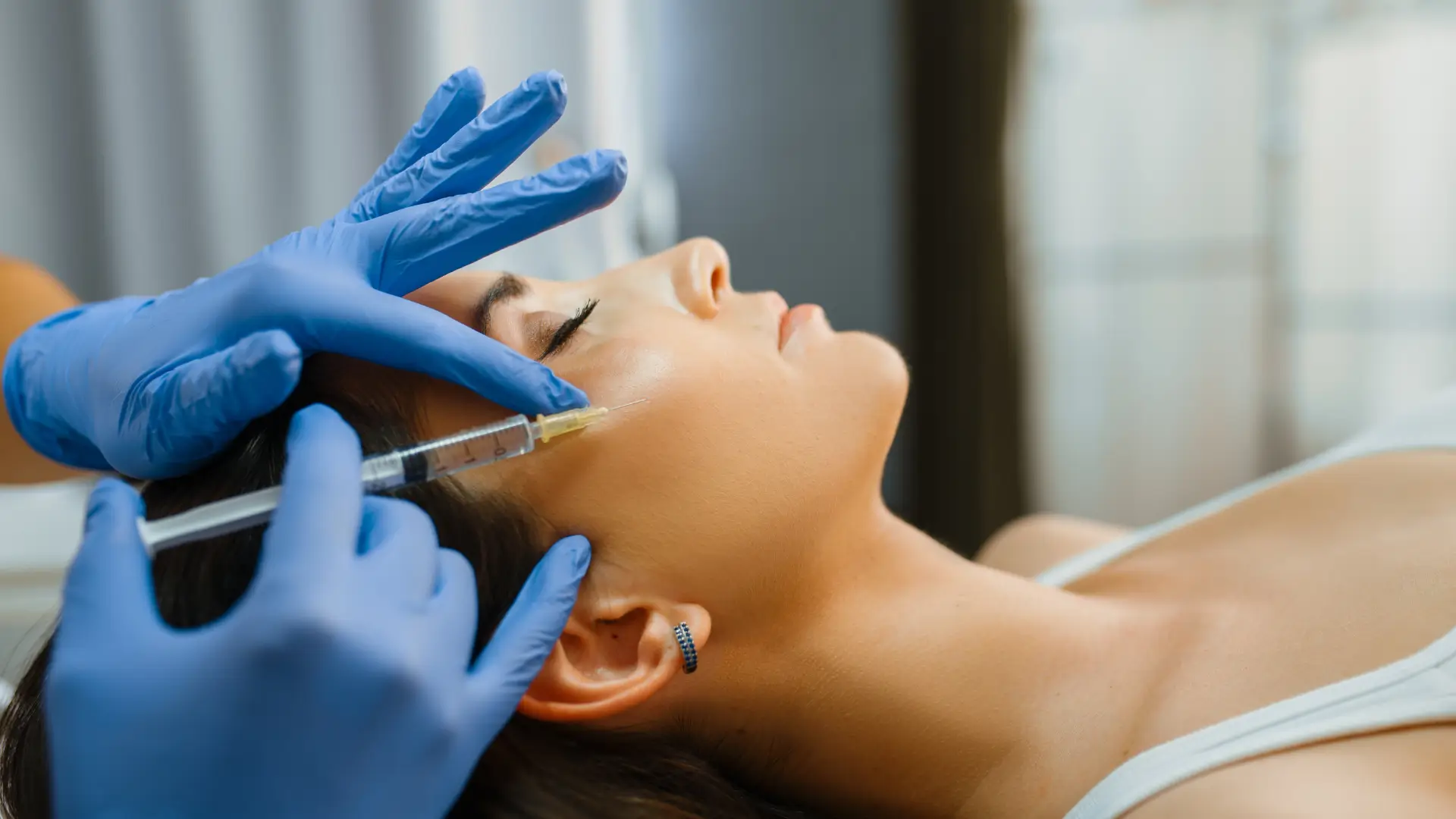 An individual receiving a botulinum toxin injection for their cheek region.