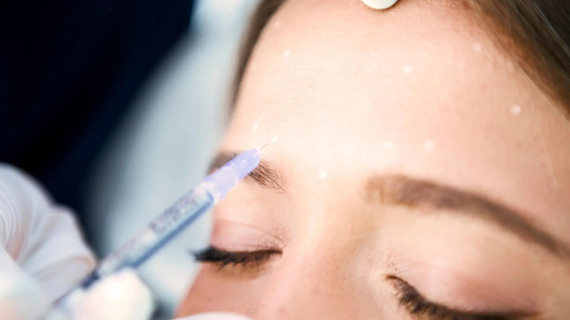 An individual receiving an injection on their forehead.