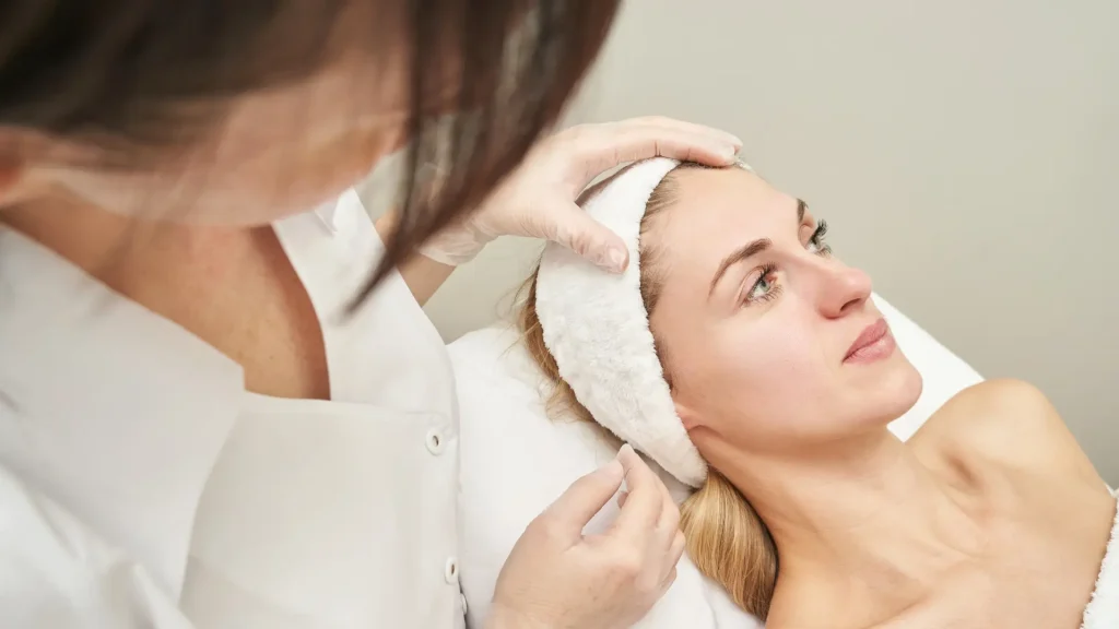 A medical professional evaluating a patient's facial region.