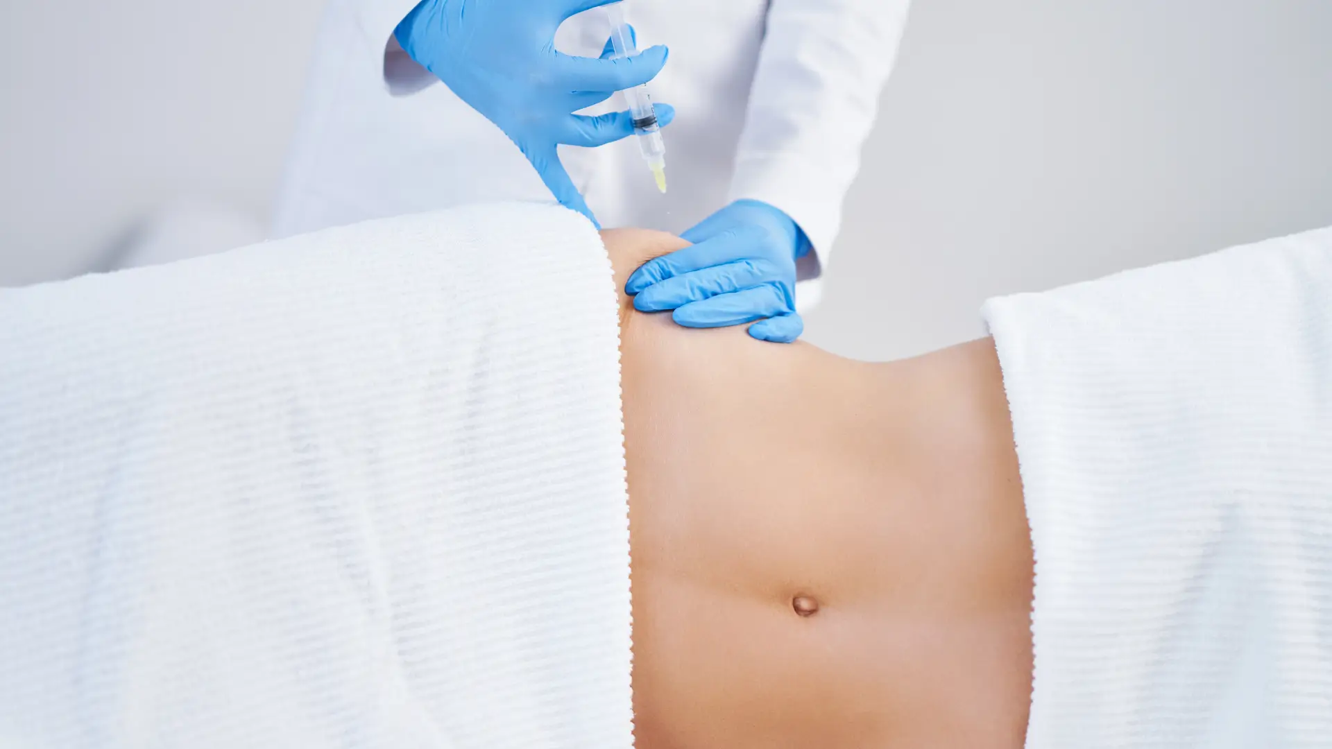 An individual receiving a lipolysis injection for their abdomen.