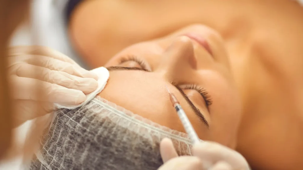 An individual receiving a botulinum toxin injection for their forehead wrinkles.