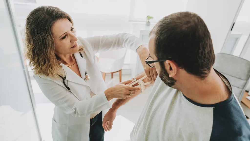 A medical professional measuring a patient's upper arm.