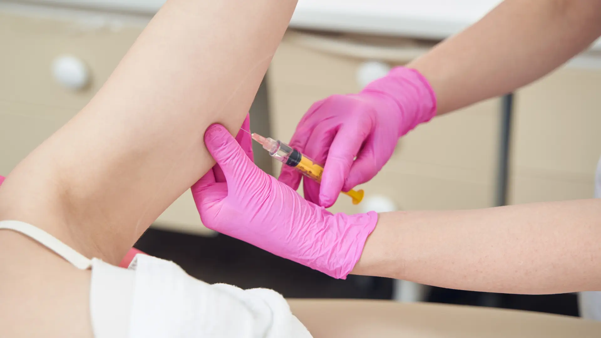 An individual undergoing a lipolytic injection to burn fat in their upper arm.