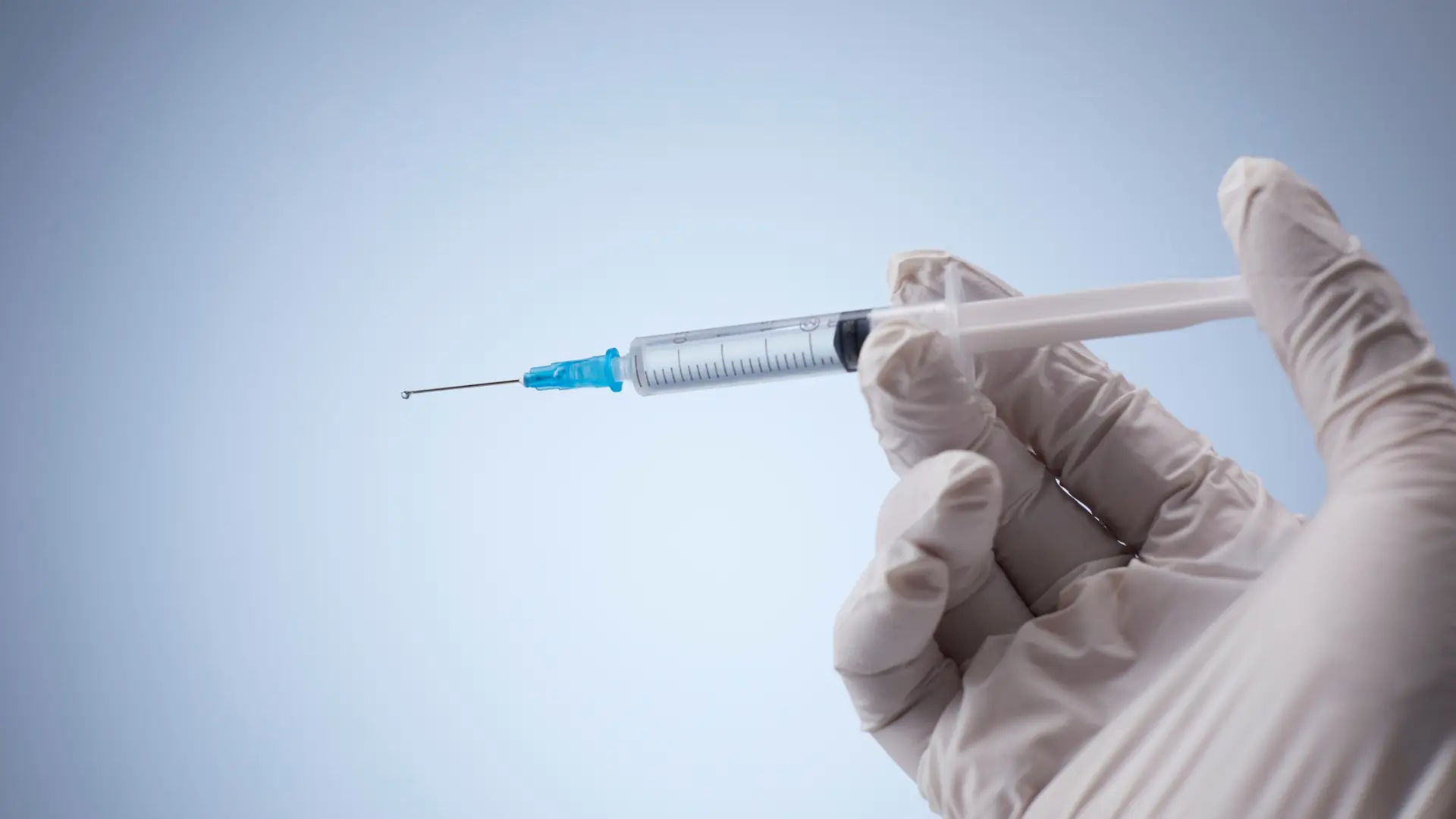 A medical professional holding an injection syringe.