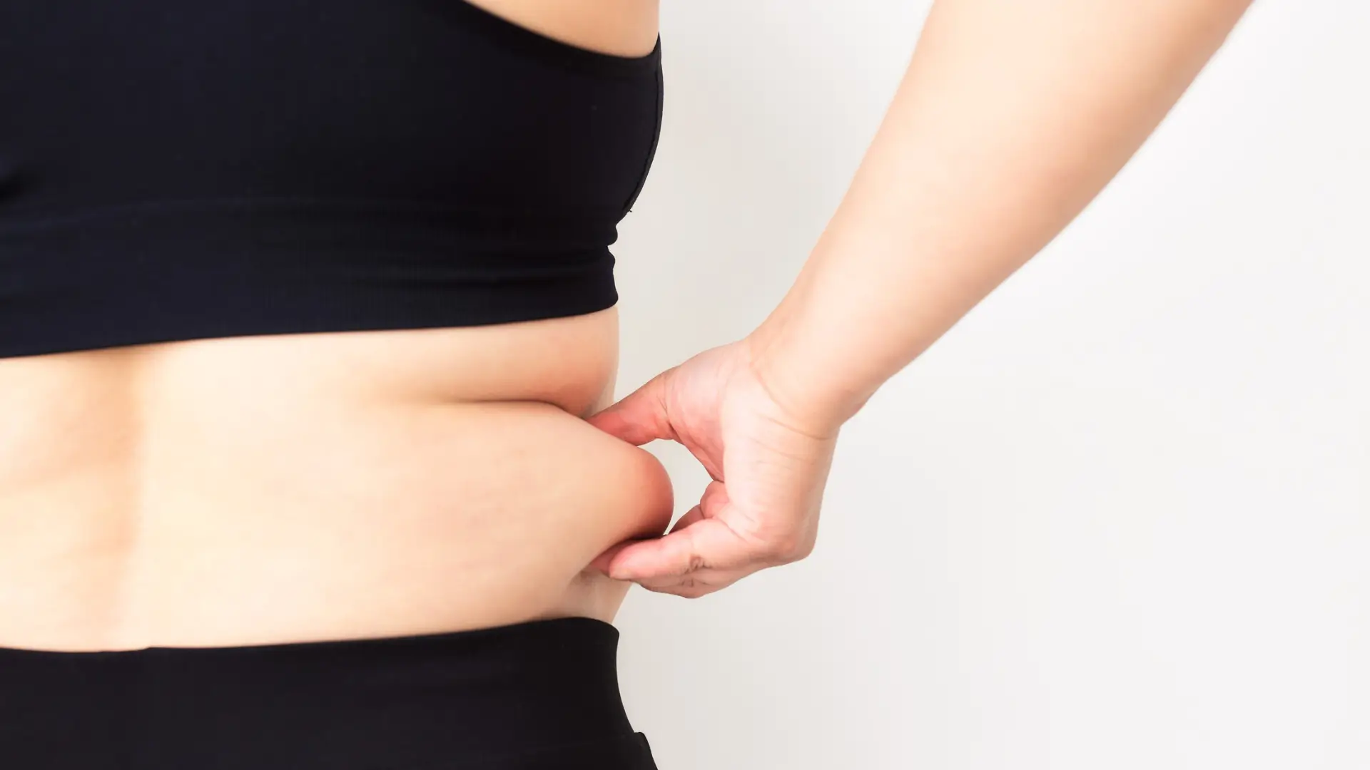 An individual dealing with fat on the side of their abdomen.