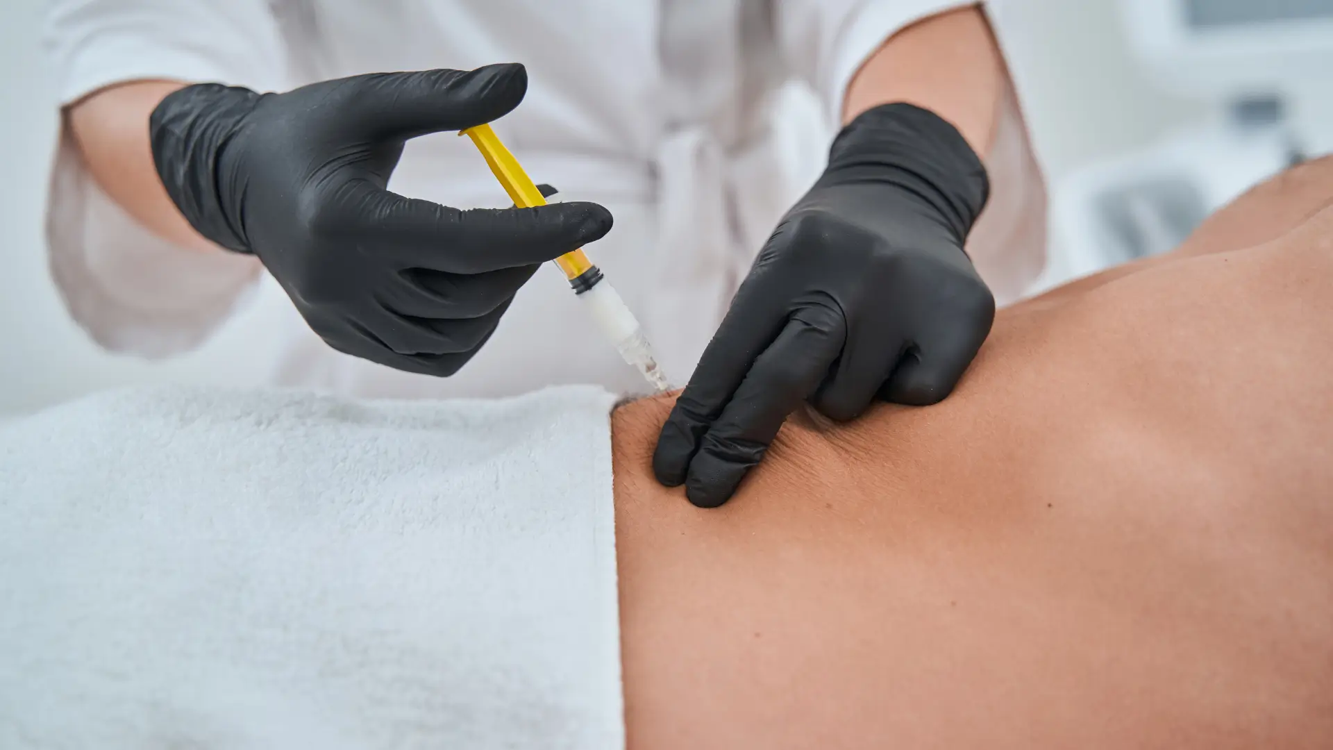 An individual receiving a noninvasive injection for their back rolls.