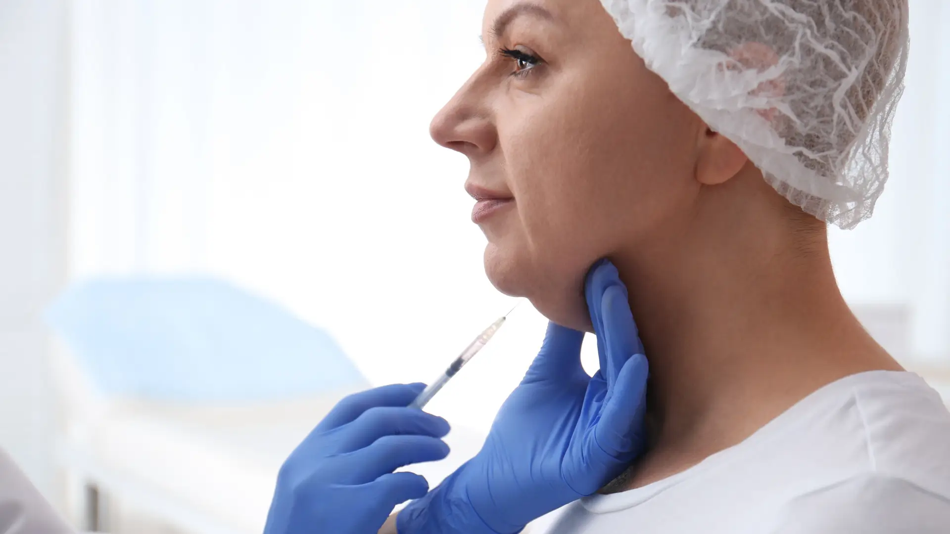 An individual undergoing a noninvasive double chin treatment.