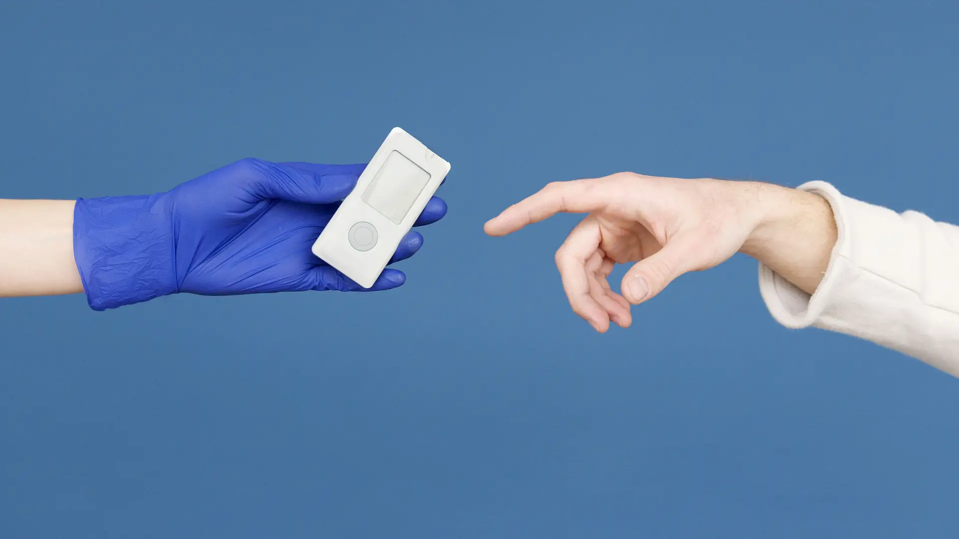 A medical professional reaching out a glucometer to a patient.