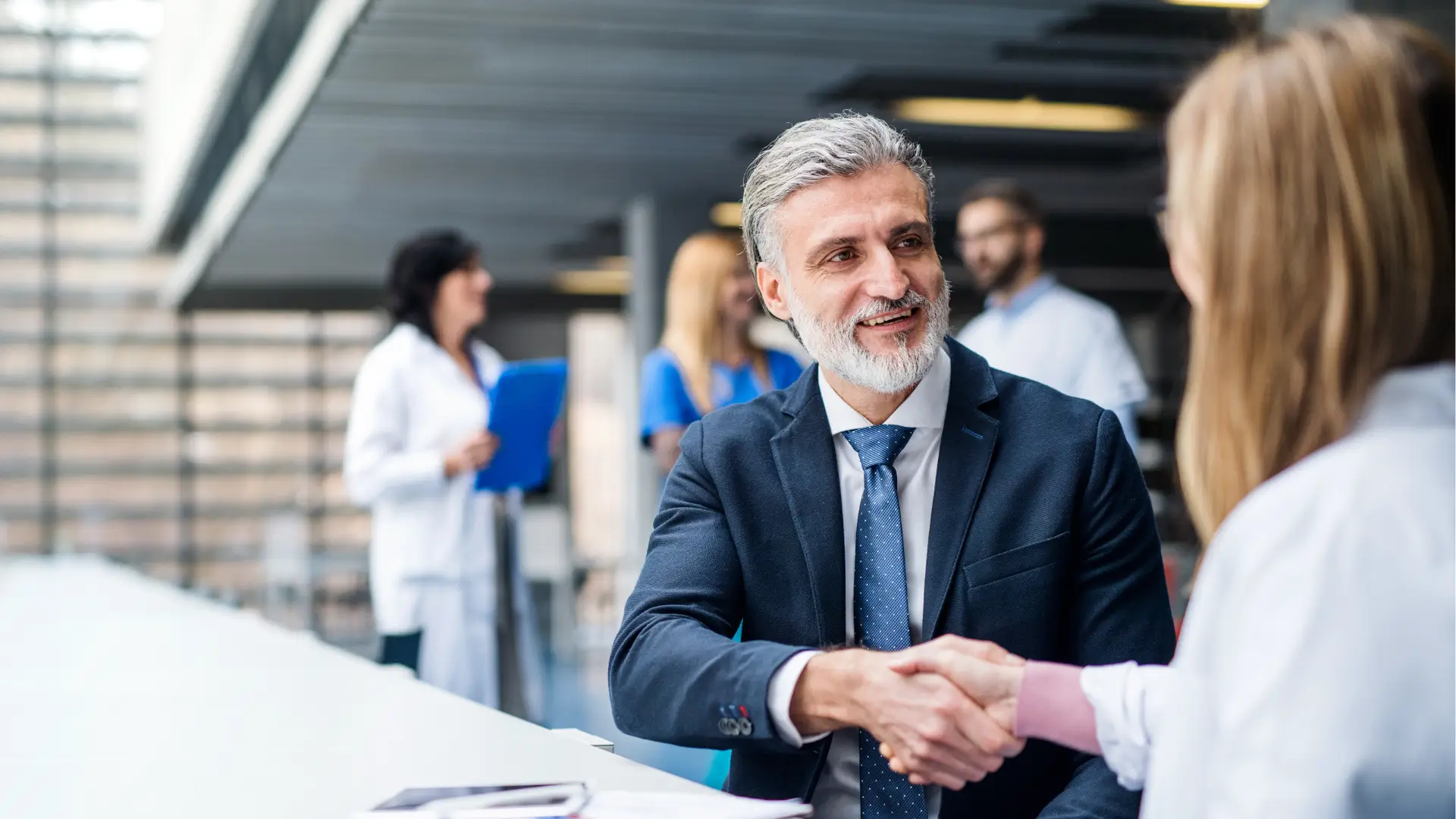 A businessman and medical professional shaking hands.