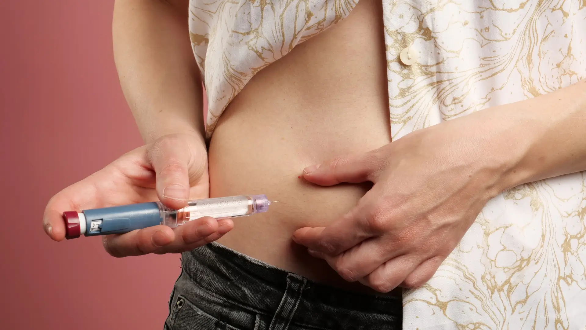 An individual self-administering their diabetes injection pen.