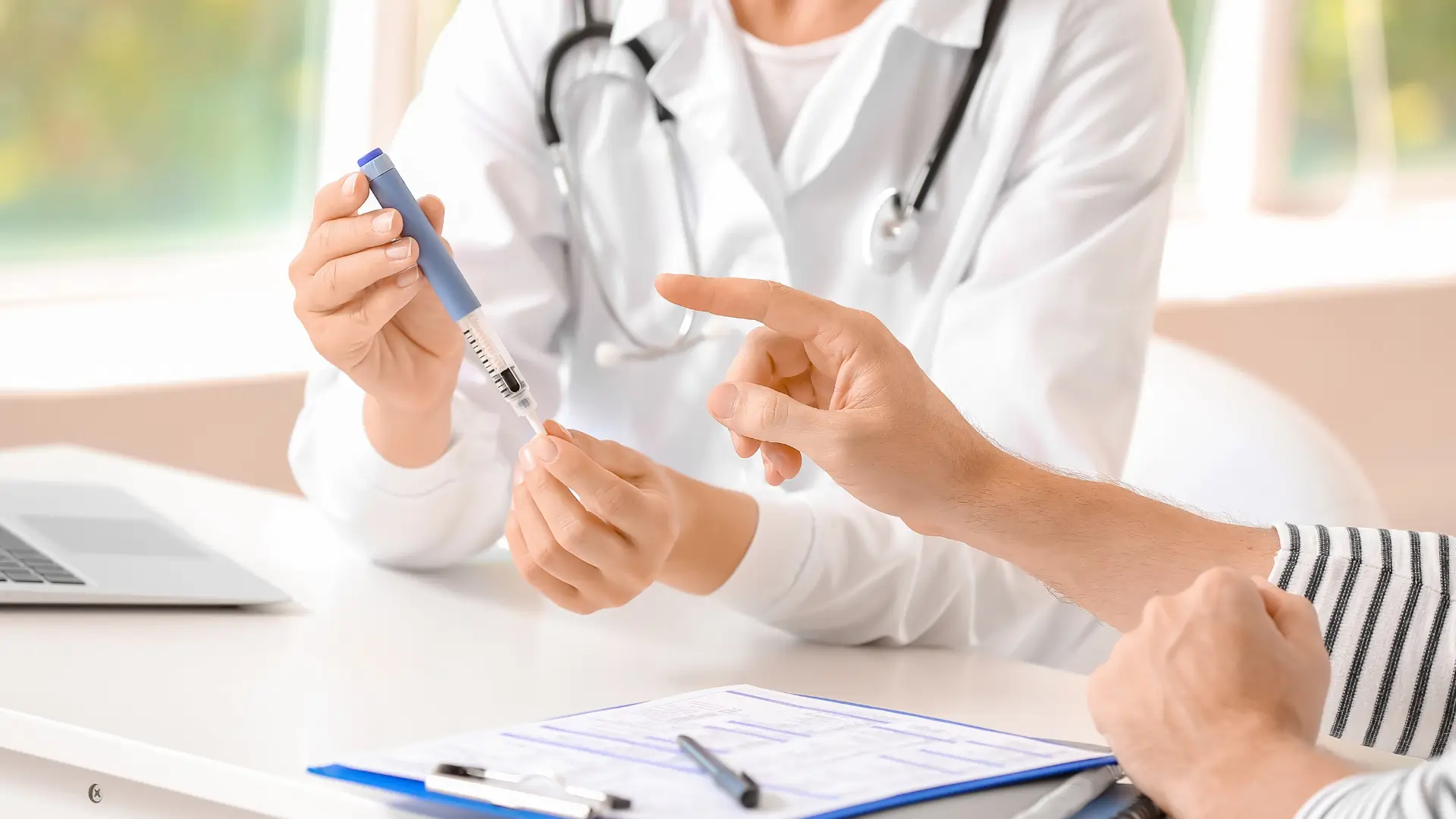 A medical professional explaining the injector pen, like Mounjaro, and how to use it to a diabetic patient.