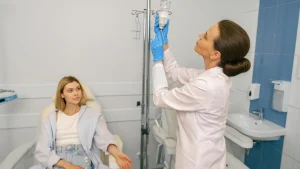 A medical provider preparing a female patient's IV infusion, similar to NAD IV treatment.