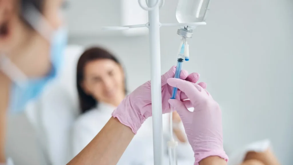 A focused shot on a practitioner mixing the formulation to saline before a patient's NAD IV infusion therapy.