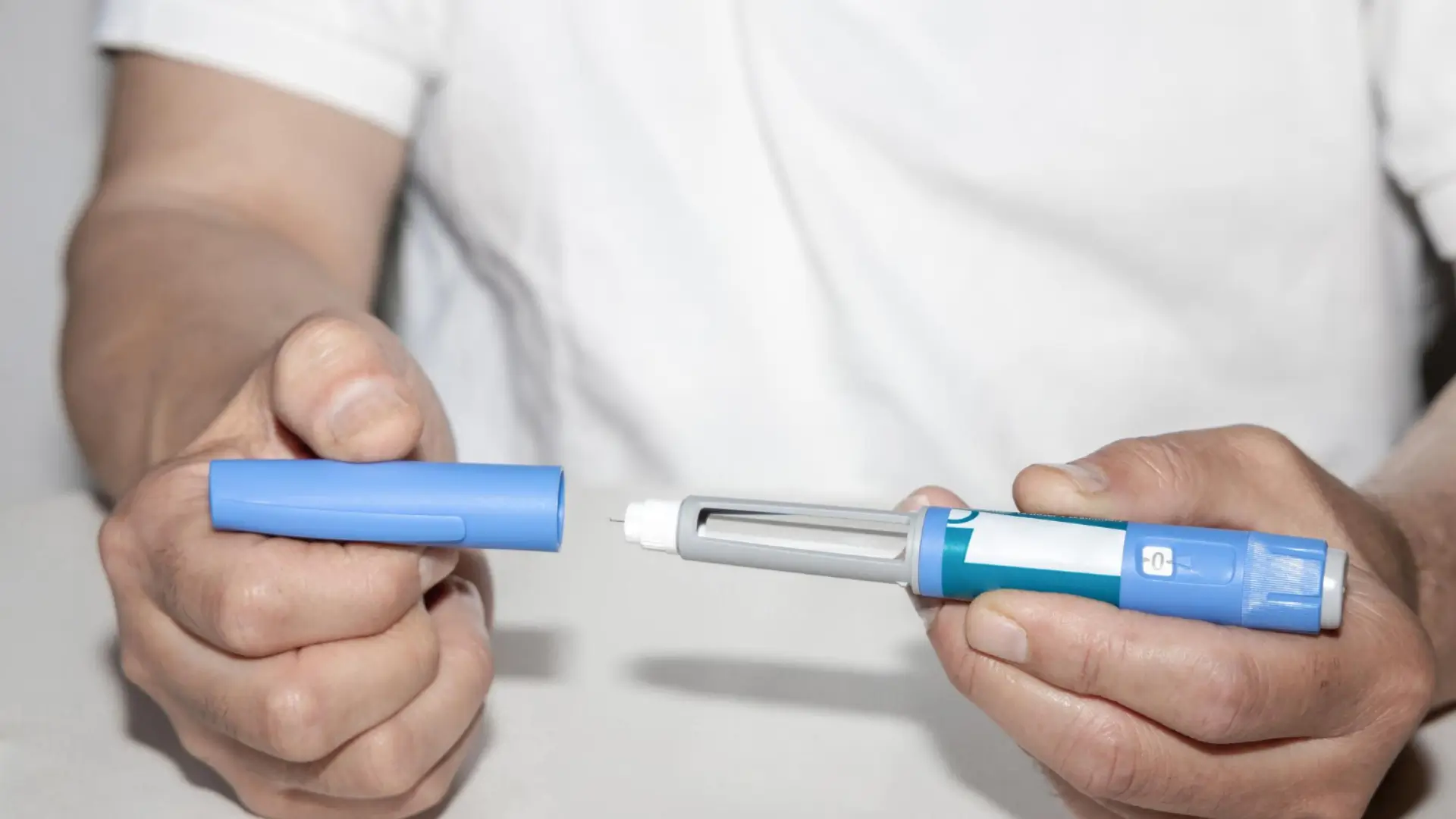 An individual holding the Ozempic pen, preparing for their injection session for improved glycemic control.