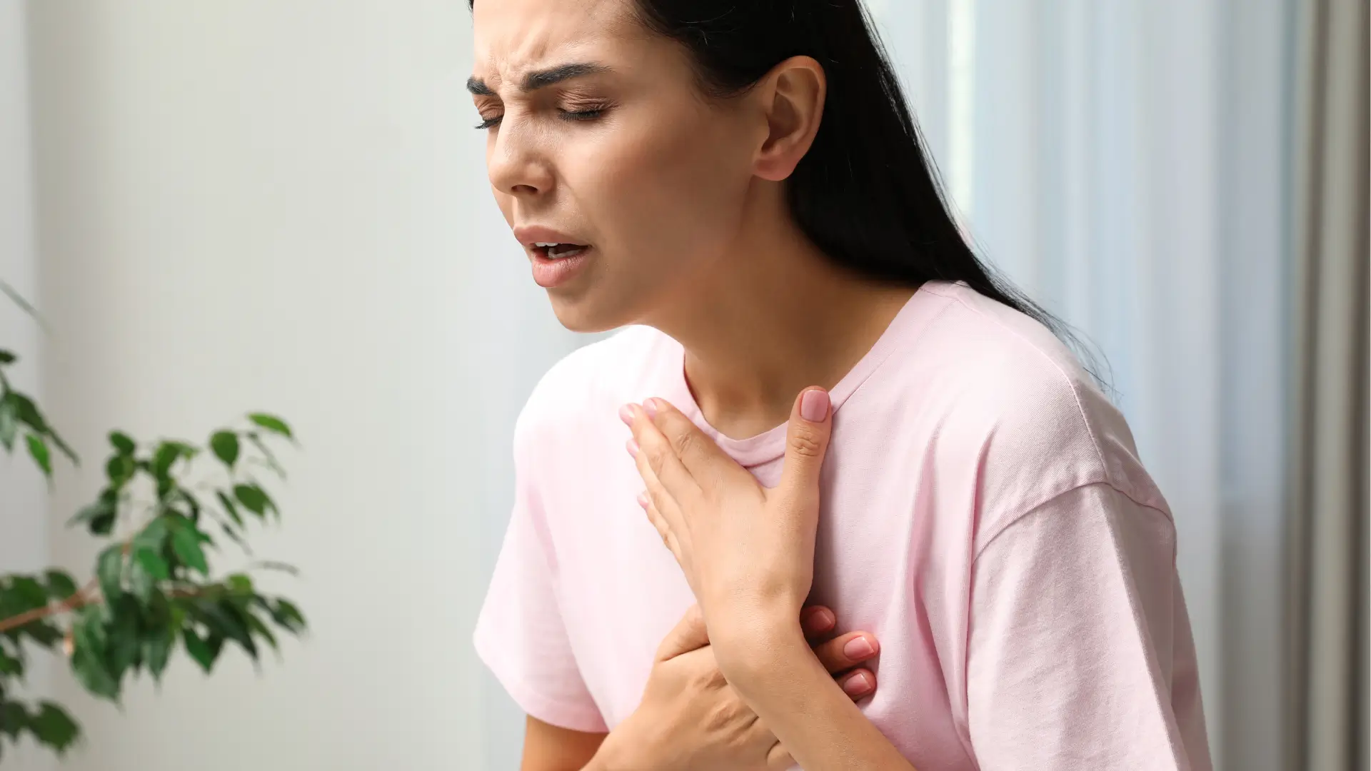 A woman suffering from breathing difficulty that may be a symptom of Xolair anaphylaxis risk.