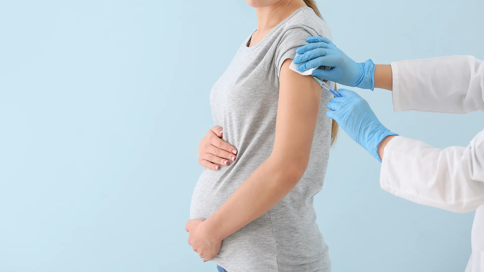 A pregnant woman receiving an injection on the outer arm, similar to how medical professionals administer Xolair injections.