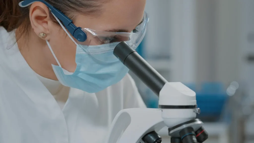 A researcher working on a microscope in laboratory for a new research peptide formulation, like Ipamorelin.